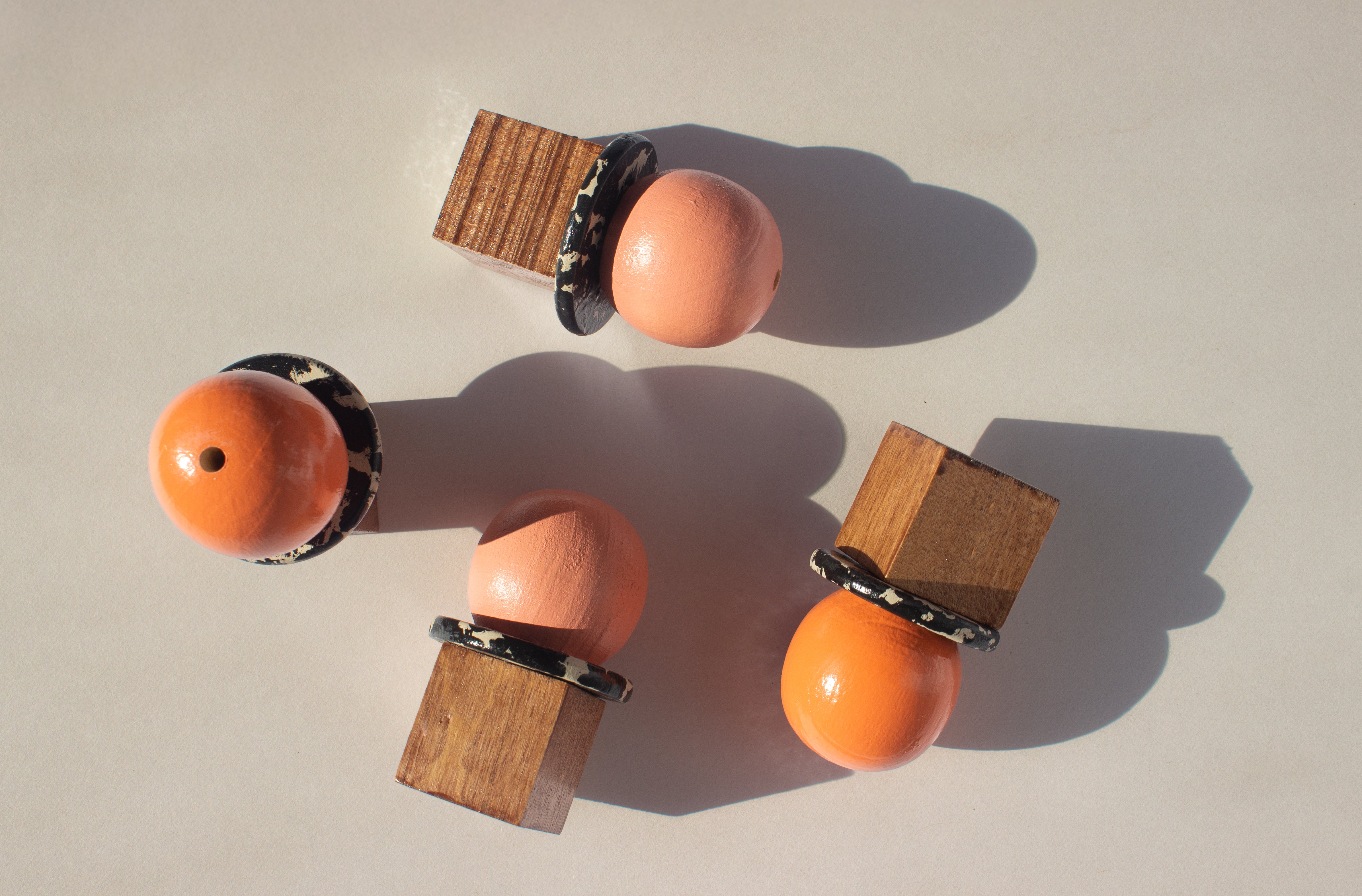 Wooden and orange spherical objects on a beige background